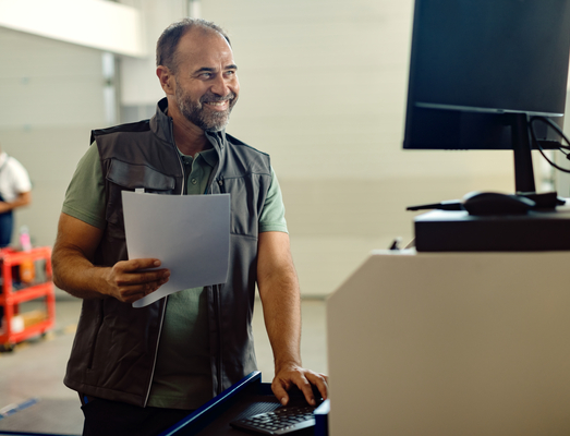 happy-mid-adult-mechanic-working-computer-auto-repair-shop