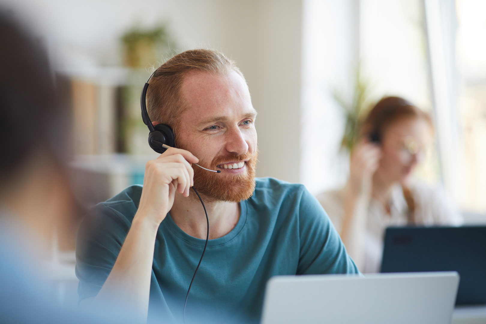 mature-bearded-man-headphones-working-table-with-laptop-office